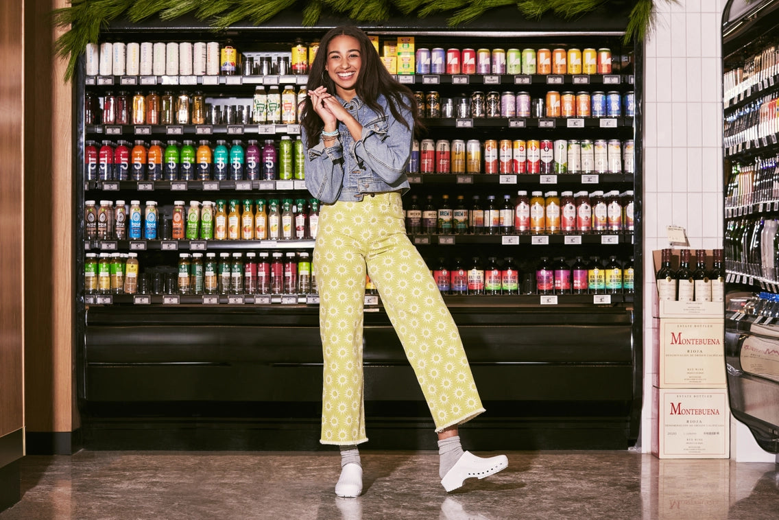 Person standing in front of a vending machine filled with drinks