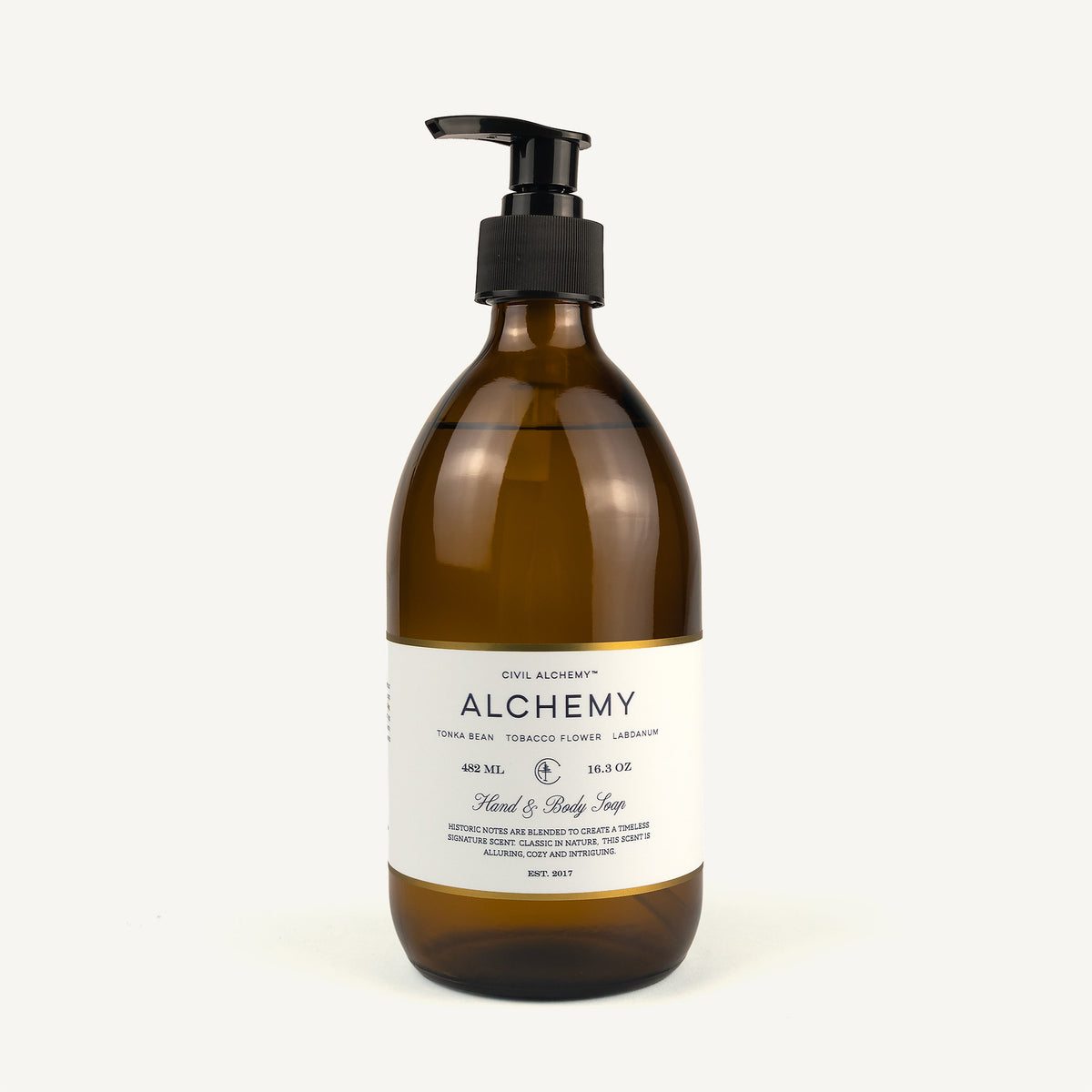 Alchemy Hand & Body Soap in a 450 mL amber glass bottle with a black pump dispenser and a white label, set against a plain off-white background.