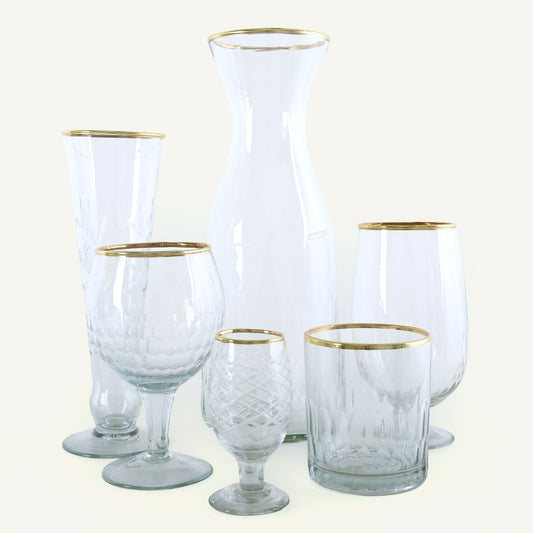 Set of clear glassware with gold rims on a white background