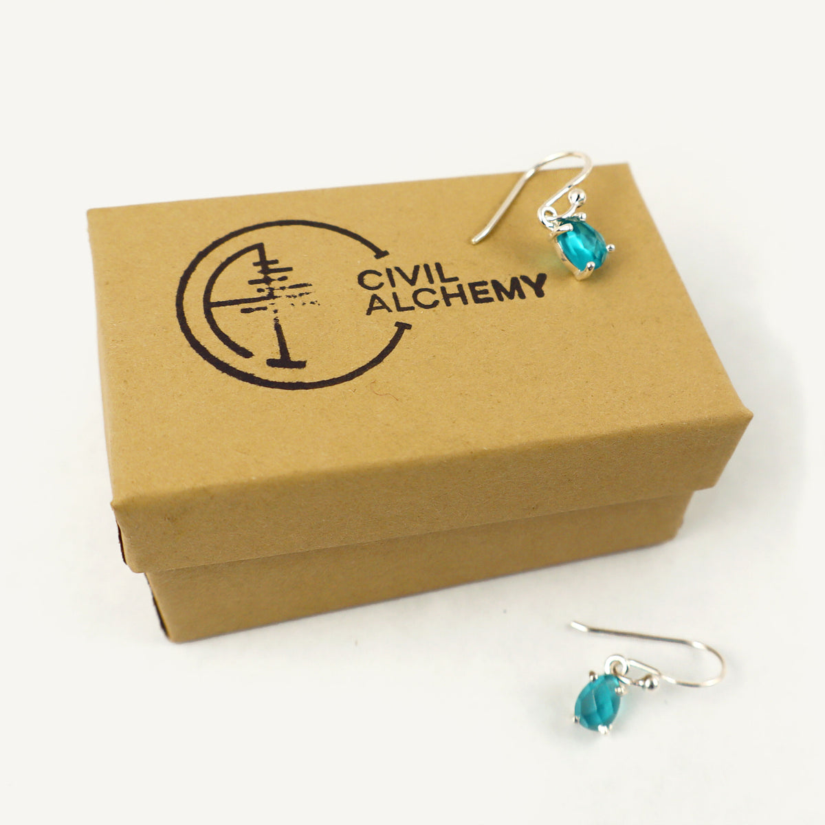 Blue Apatite earrings on a cardboard box with 'Civil Alchemy' branding.