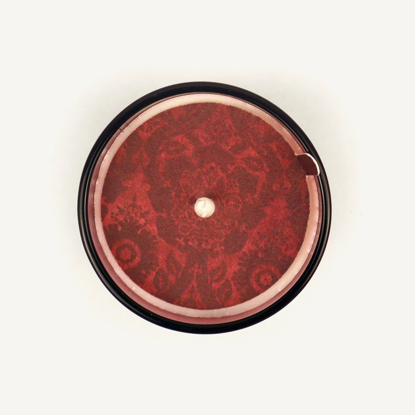 Round red object with intricate design on a white background
