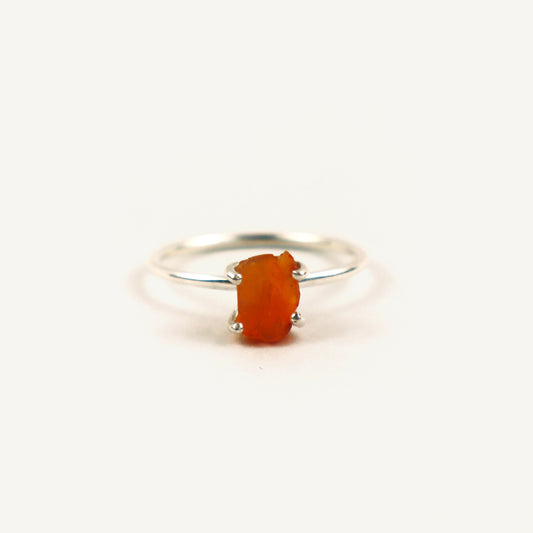 Silver ring with a red stone on a white background