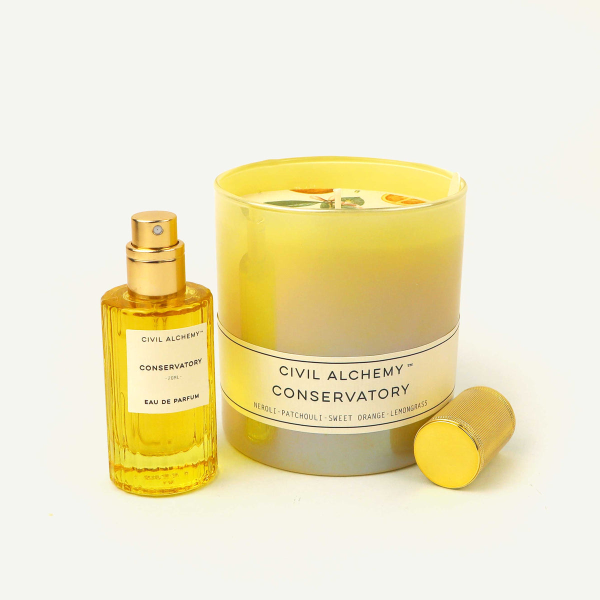 Perfume bottle and candle set with 'Civil Alchemy Conservatory' branding on a light background