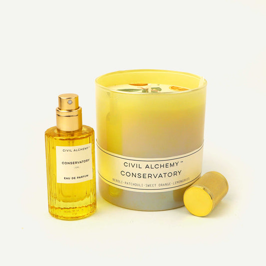 Perfume bottle and candle set with 'Civil Alchemy Conservatory' branding on a light background