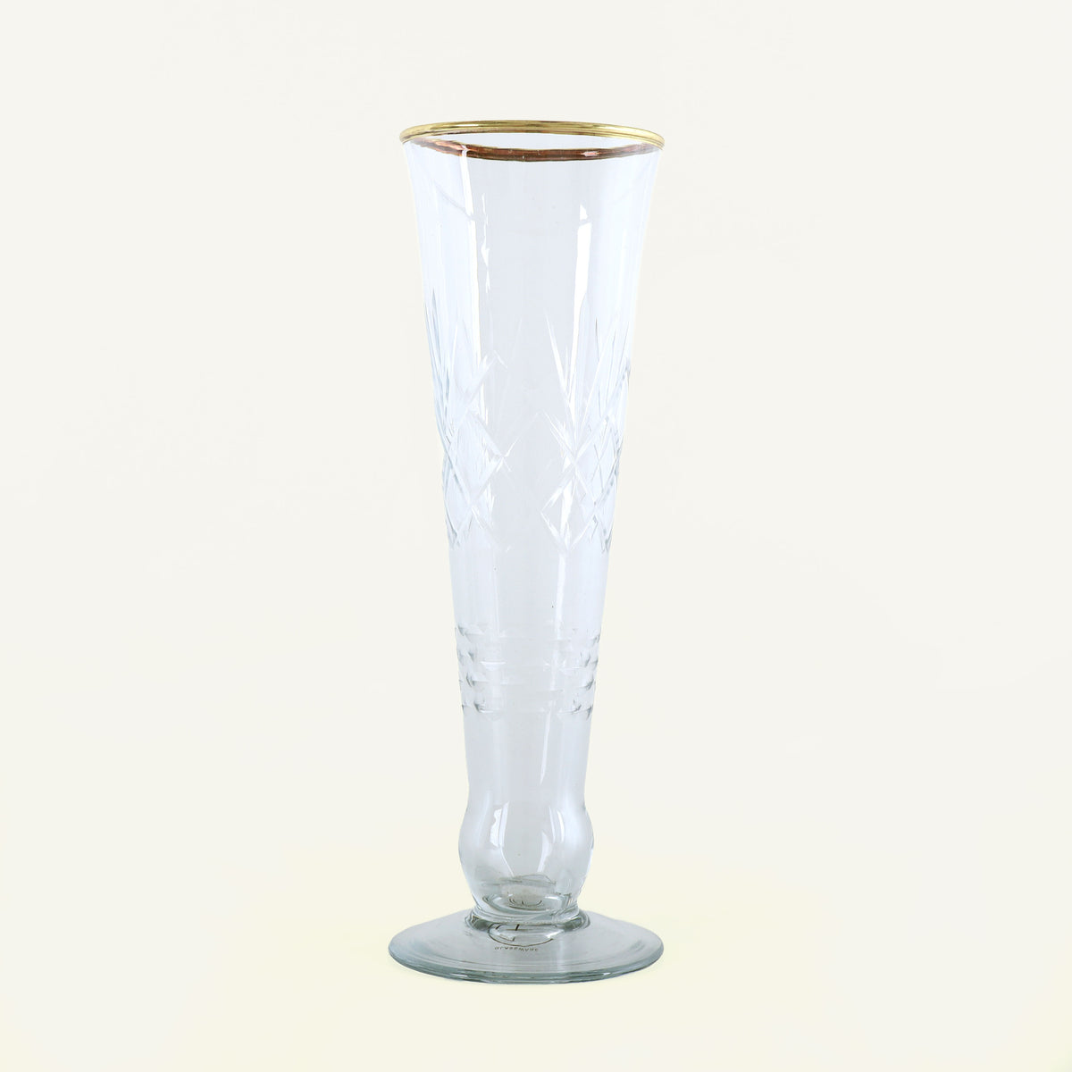 Clear glass flute with gold rim on a white background