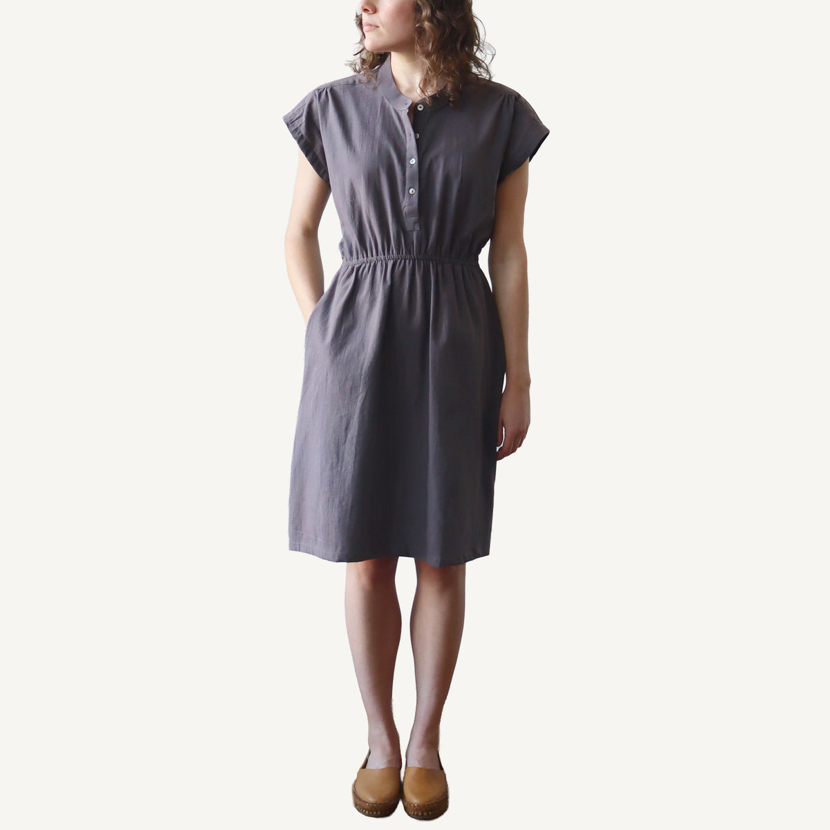 Woman wearing a gray dress on a white background