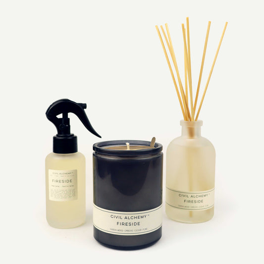 Candle, spray bottle, and diffuser with 'Civil Alchemy Fireside' label on a white background