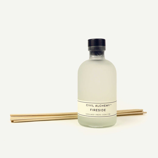 Bottle of 'Fireside' diffuser with reeds on a white background