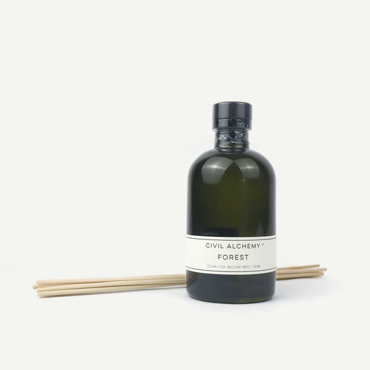 Green bottle with label and wooden sticks on a white background