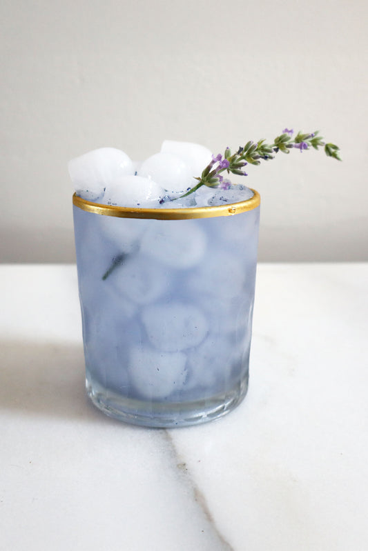 Glass with ice cubes and lavender on a marble surface