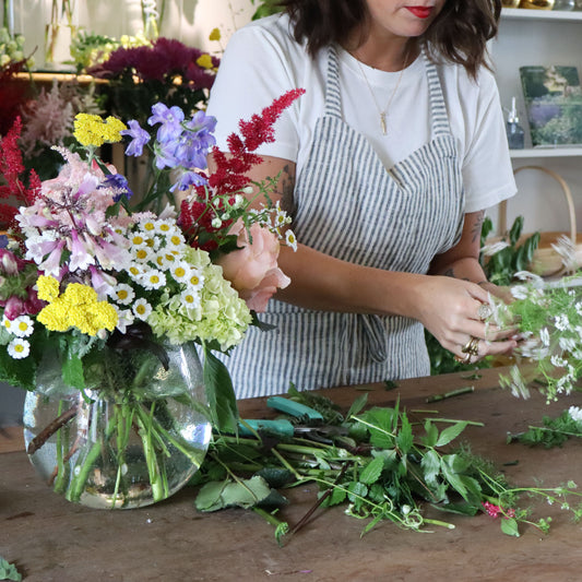 Person arranging flowers in a workshop setting