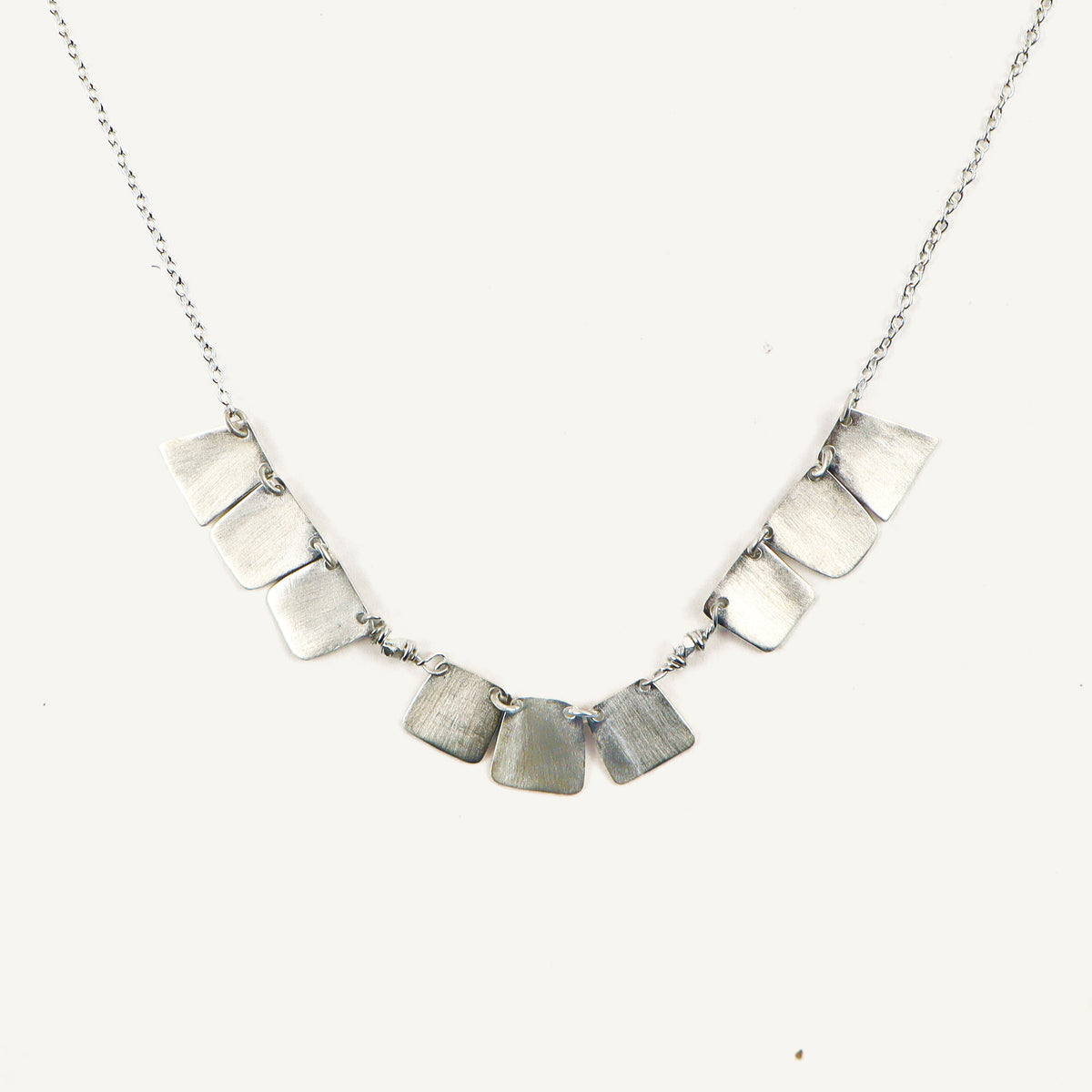 Necklace with square pendants on a white background