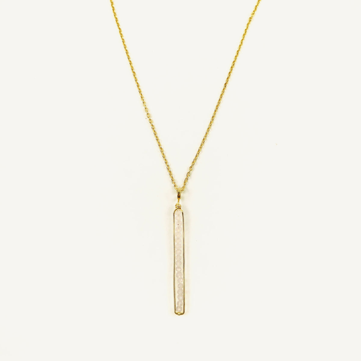 Gold necklace with a vertical bar pendant on a white background