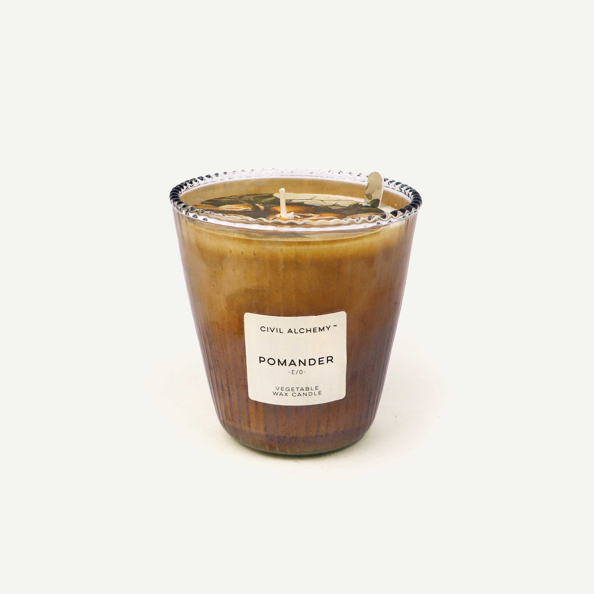 Candle in a glass jar with a label "Pomander" on a white background