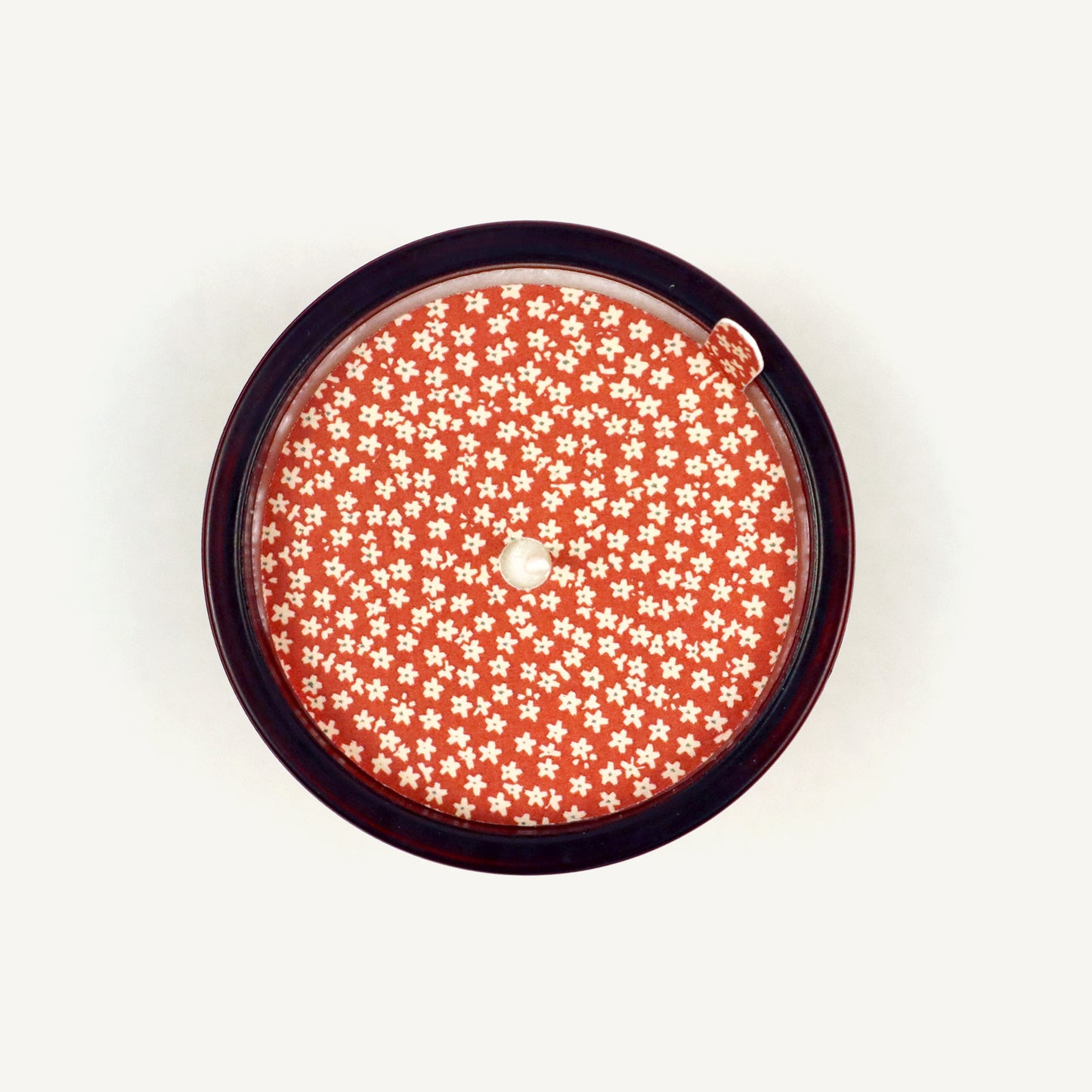 Round candle topper with floral pattern on a white background