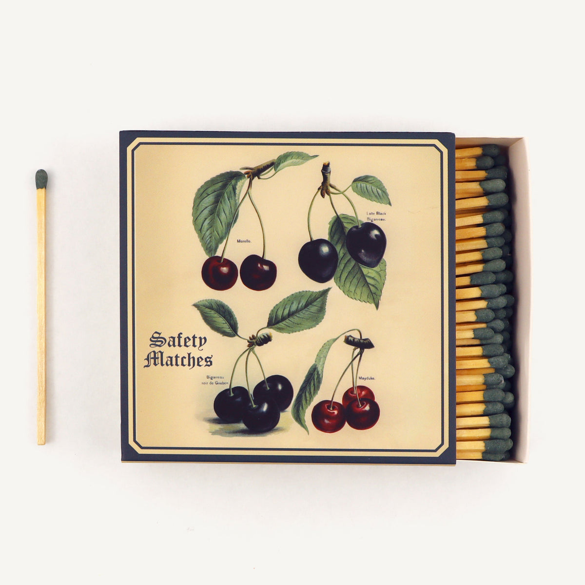 Matchbox with cherry design and safety matches on a white background