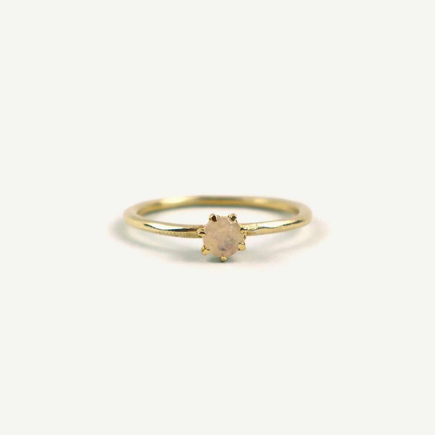 Gold ring with a small gemstone on a white background