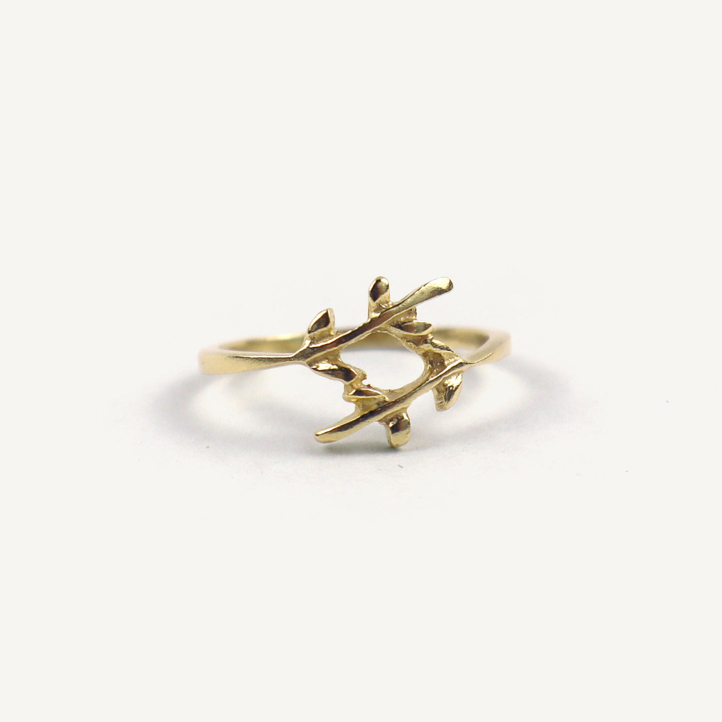 Gold branch-shaped ring on a white background
