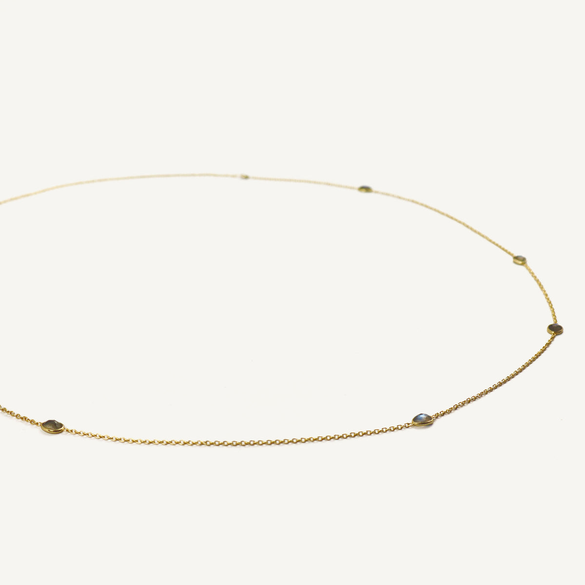 Gold necklace with small beads on a white background