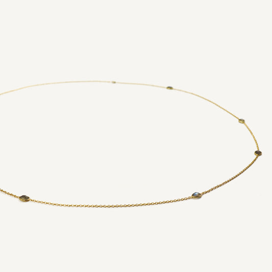 Gold necklace with small beads on a white background