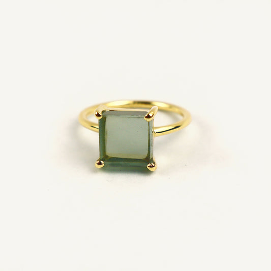 Gold ring with a green gemstone on a white background