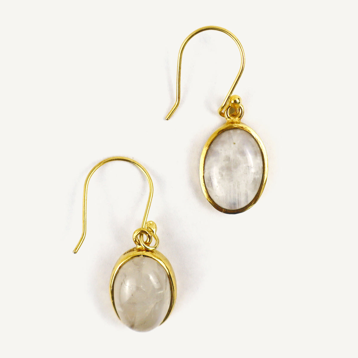 Gold earrings with oval gemstones on a white background