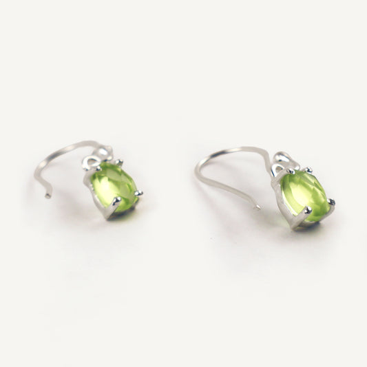 Pair of silver earrings with green gemstones on a white background