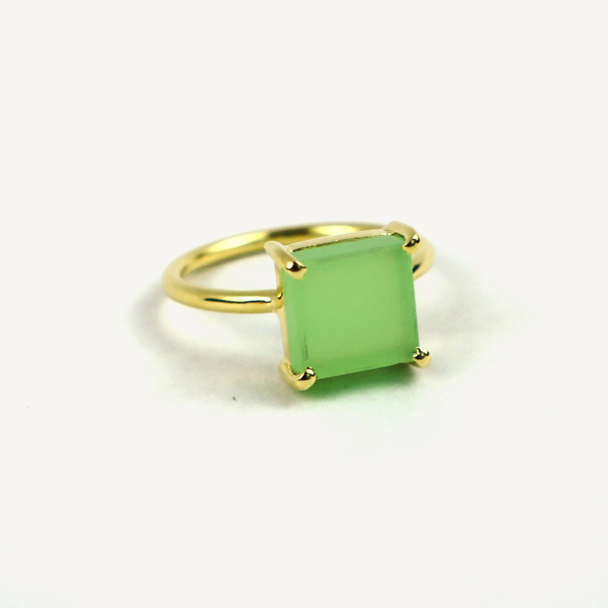 Gold ring with a green gemstone on a white background