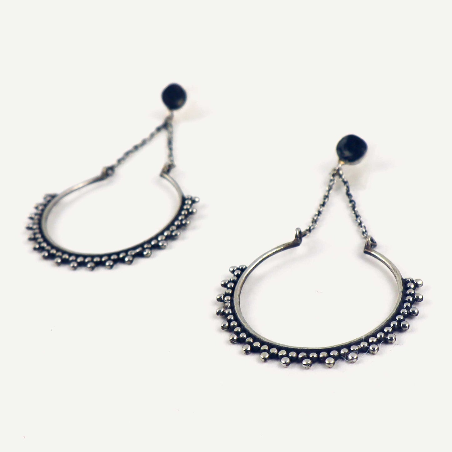Pair of silver hoop earrings on a white background.