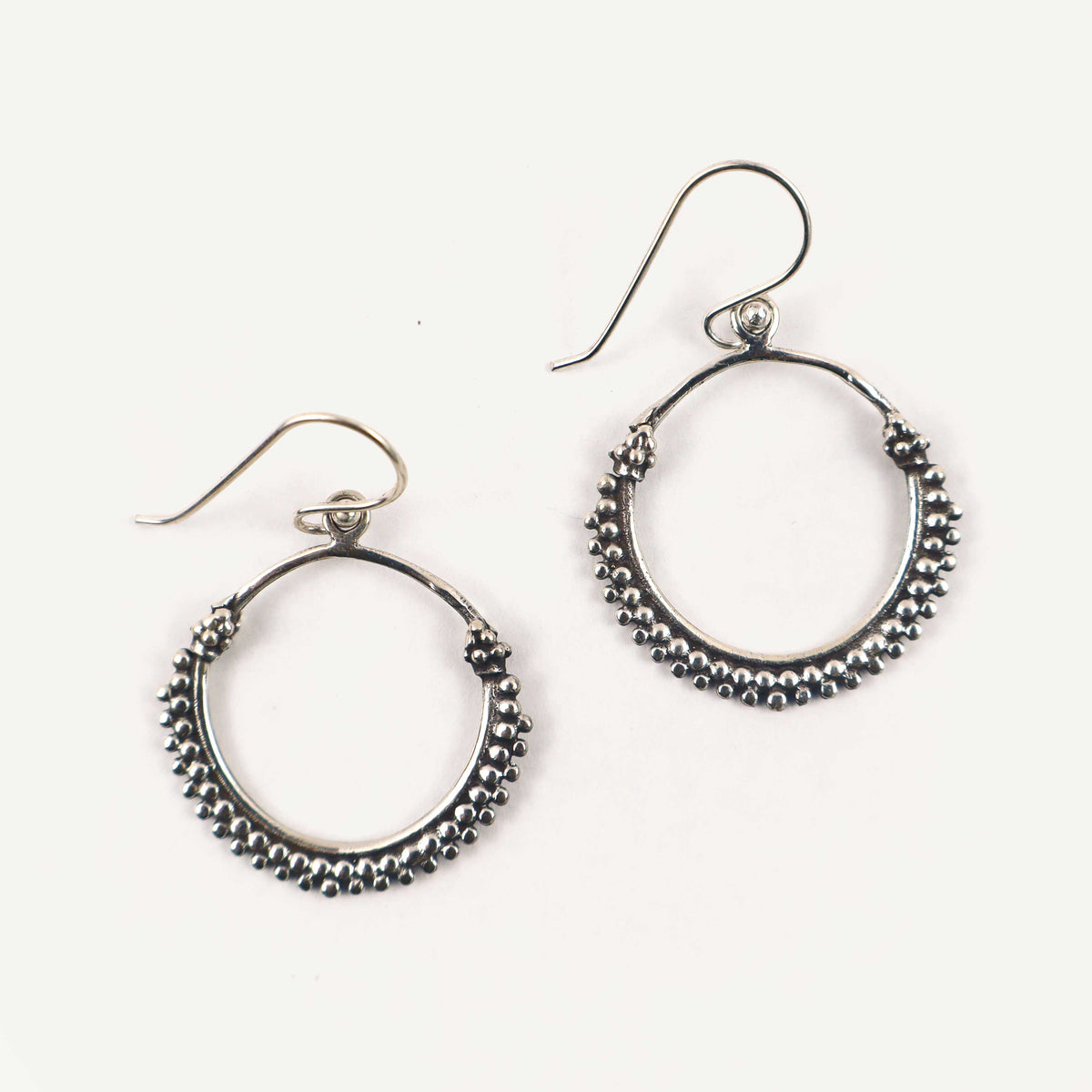 Pair of silver hoop earrings on a white background