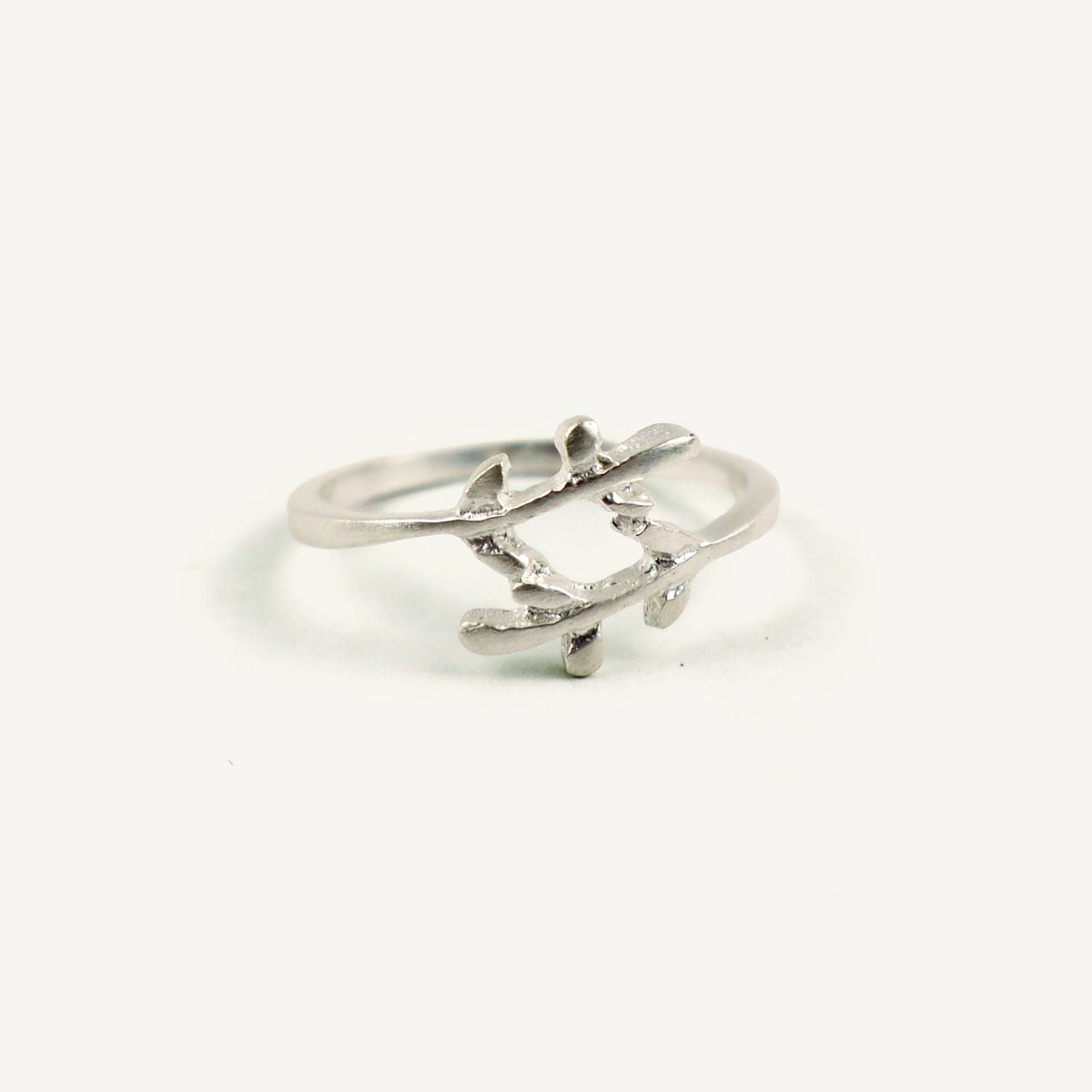 Silver ring with a leaf design on a white background
