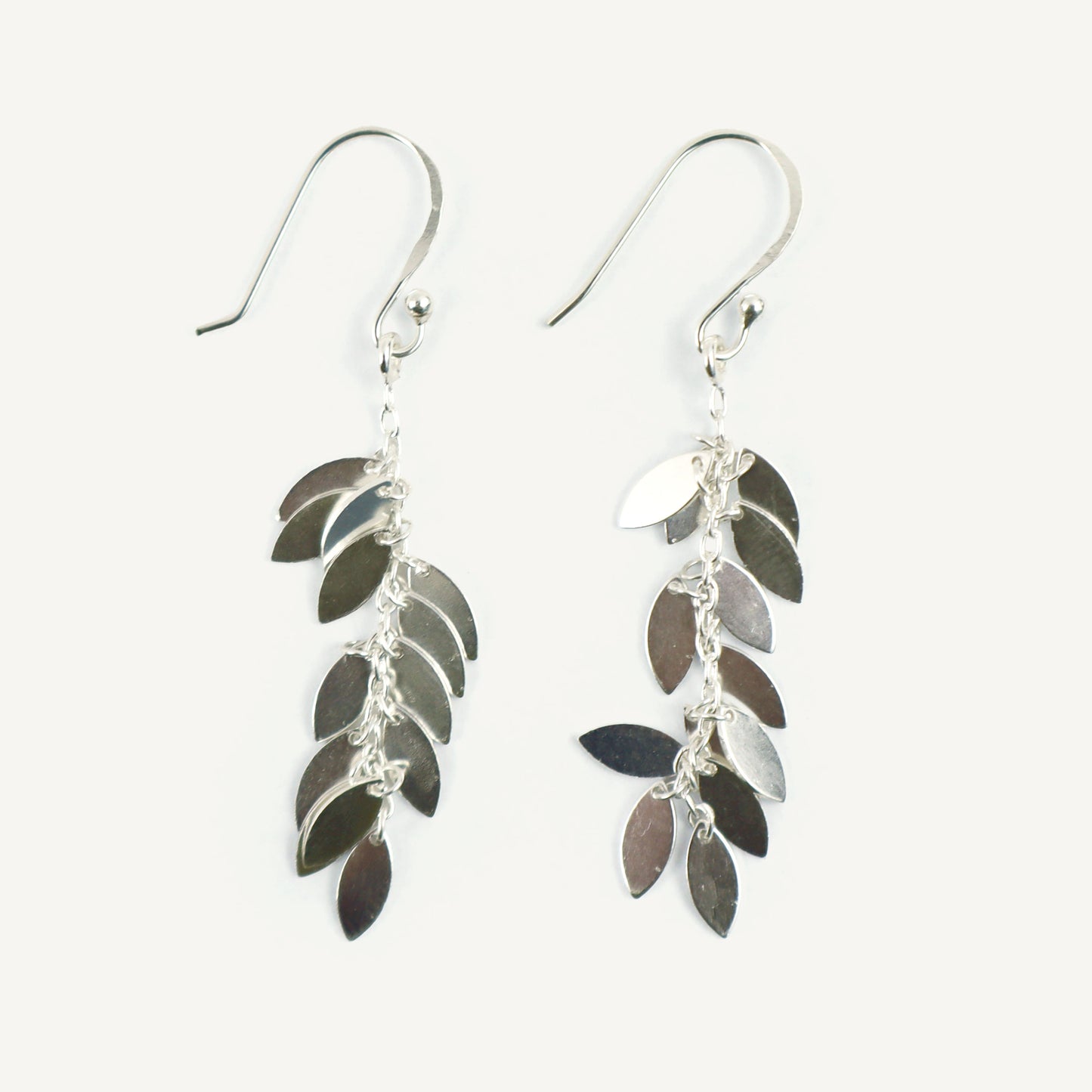 Silver leaf-shaped earrings on a white background