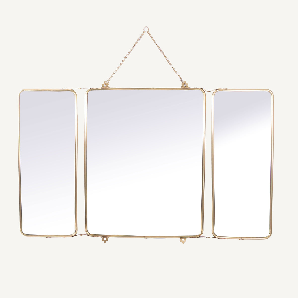 A brass triple folding mirror with three panels, each reflective, arranged in a triangular formation with the central panel being the largest and the side panels being smaller.