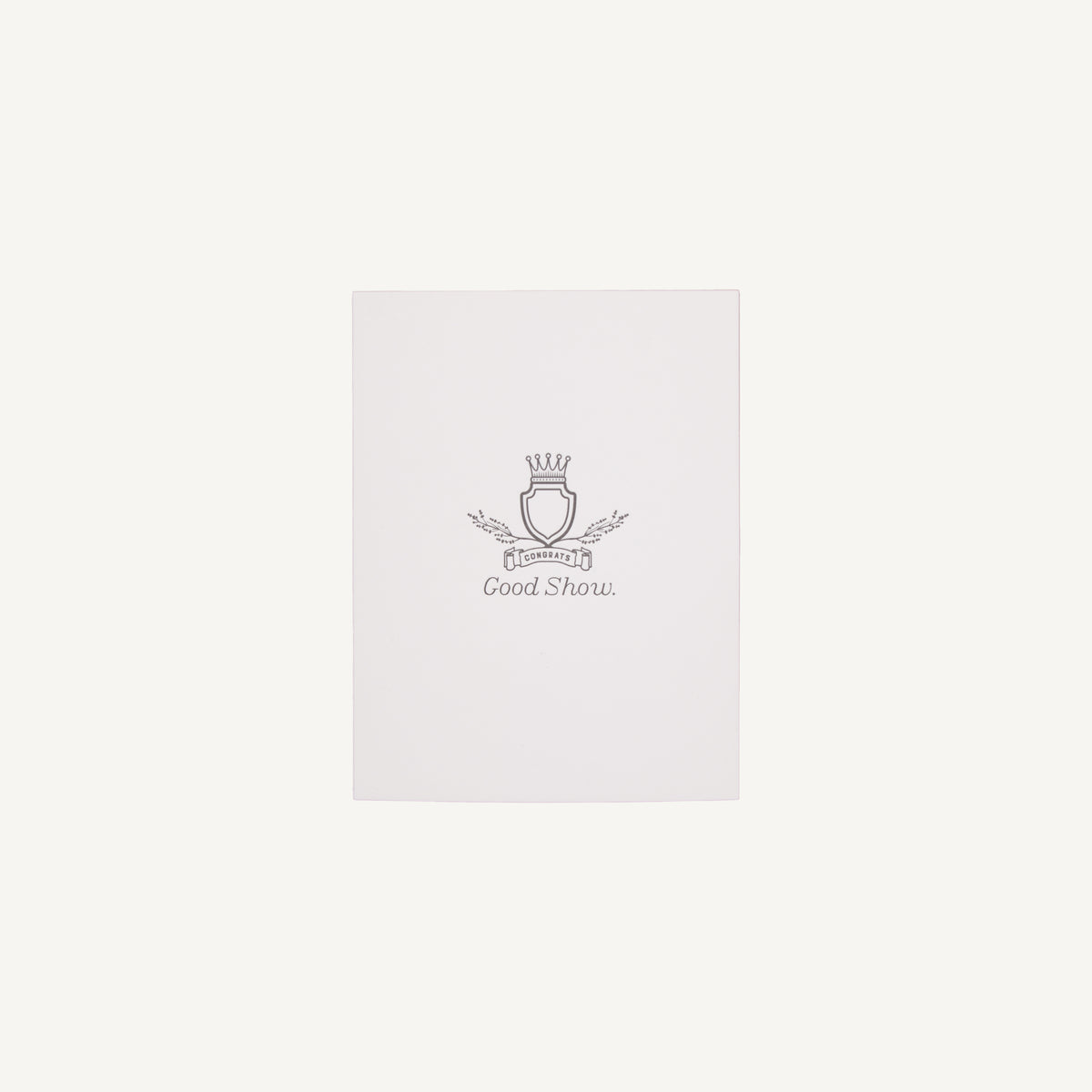 A white letterpress congratulations card with a small decorative emblem and text on the front, placed on a clear background.