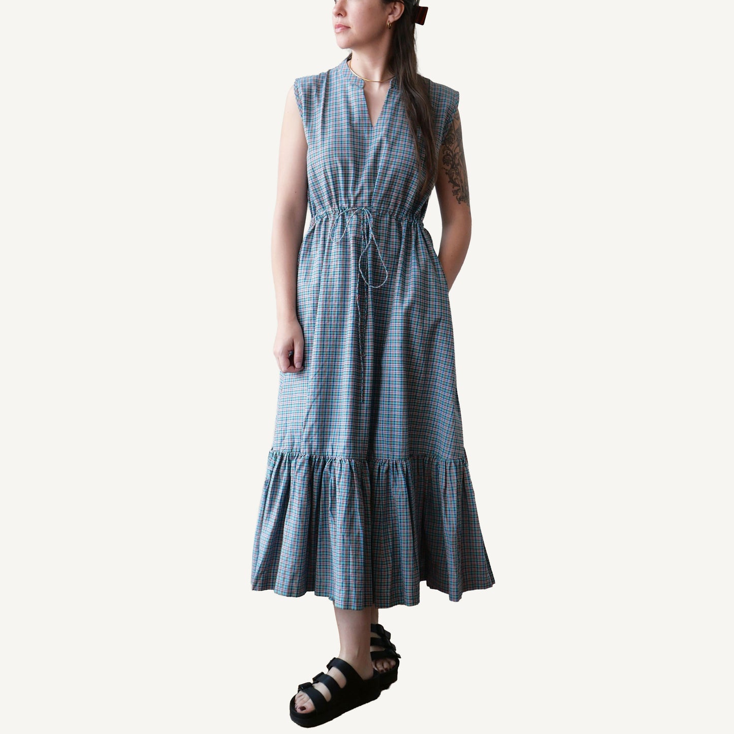 Woman wearing a blue checkered dress on a white background