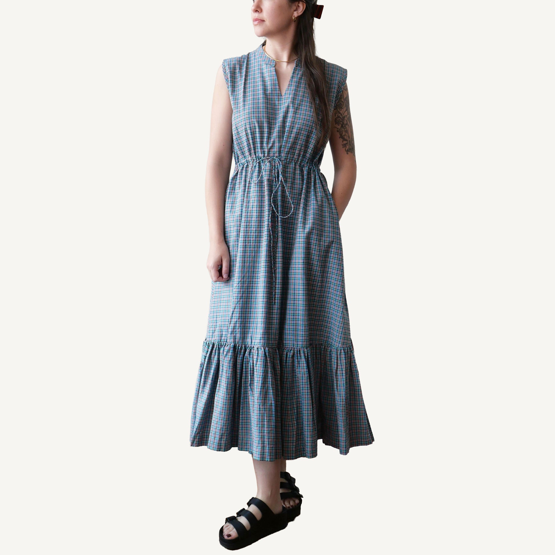 Woman wearing a blue checkered dress on a white background