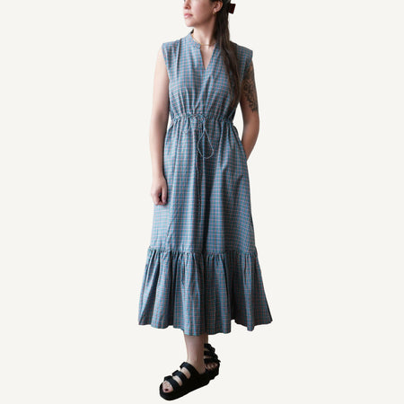 Woman wearing a blue checkered dress on a white background