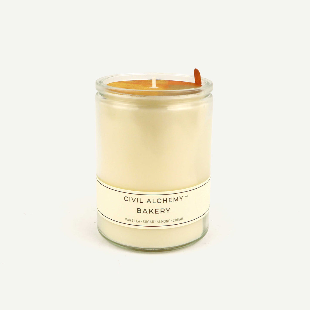Candle in a glass jar with 'Civil Alchemy' label on a white background