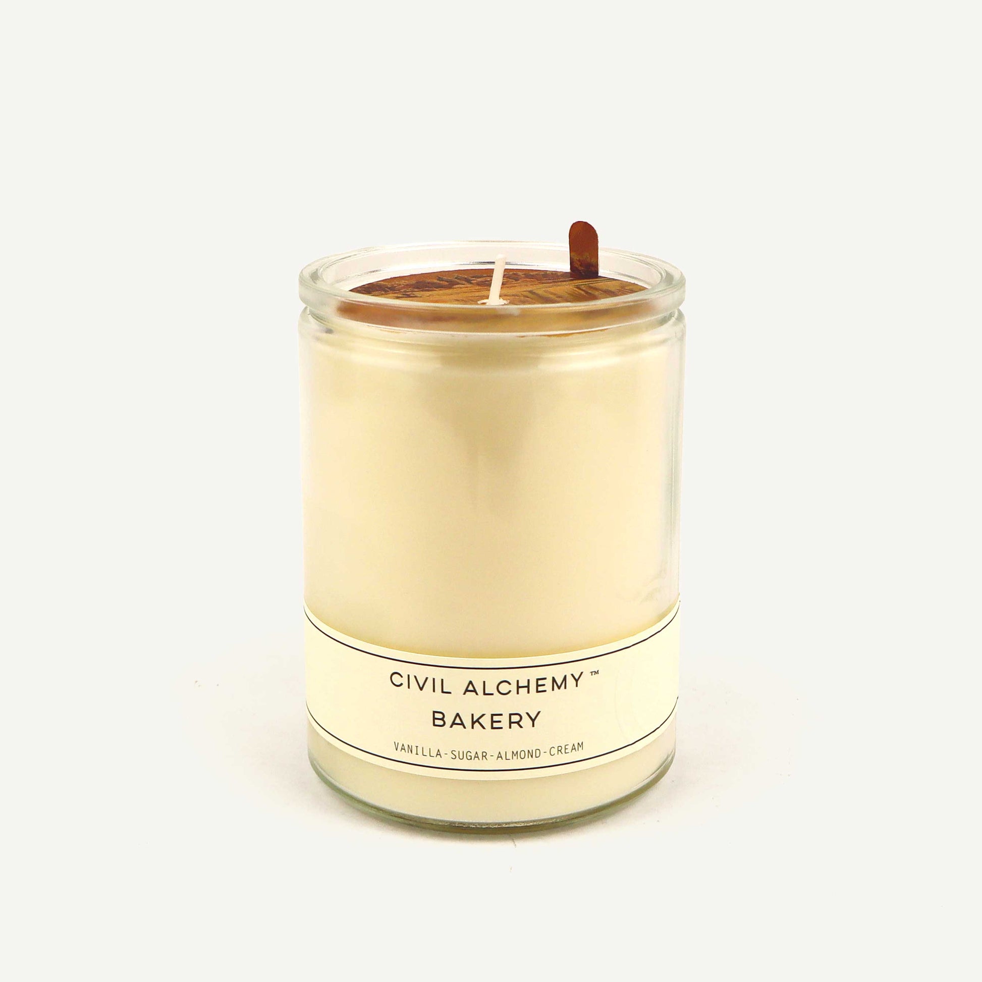 Candle in a glass jar with 'Civil Alchemy Bakery' label on a white background