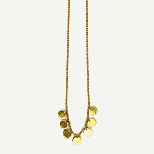 Gold necklace with round pendants on a light beige background