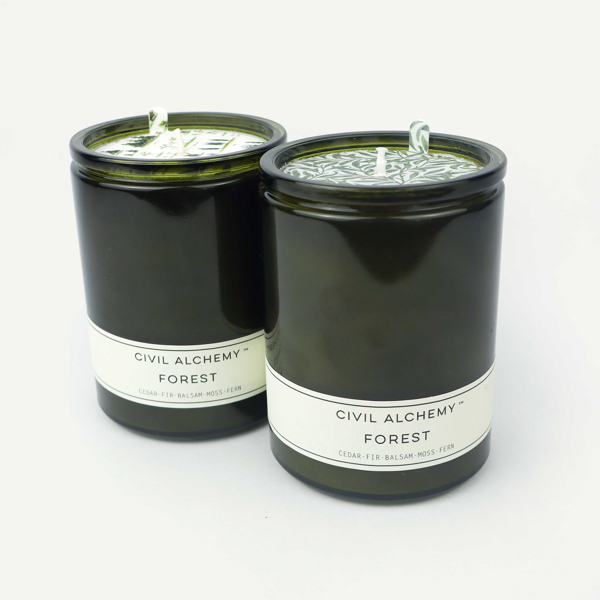 Two green candles labeled 'Civil Alchemy Forest' on a white background