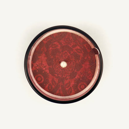 Round red object with intricate design on a white background