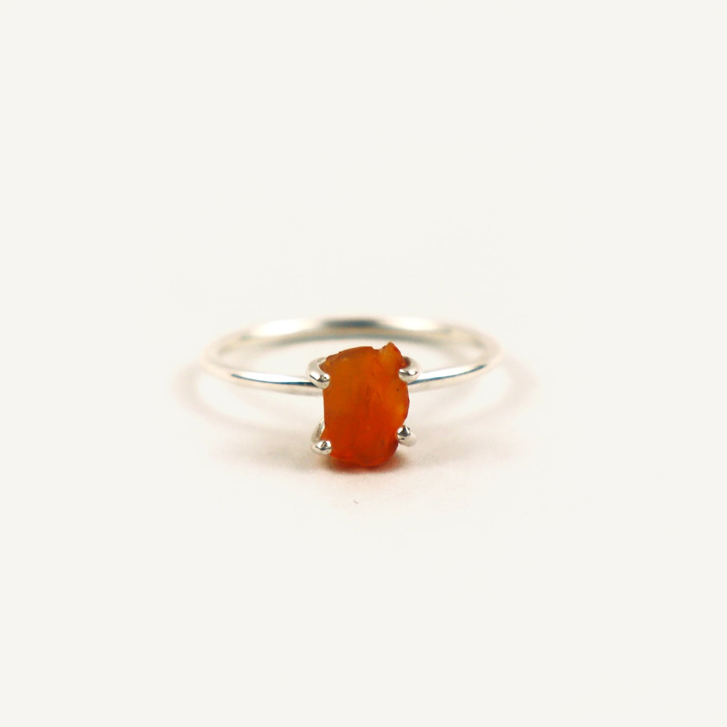 Silver ring with a red stone on a white background