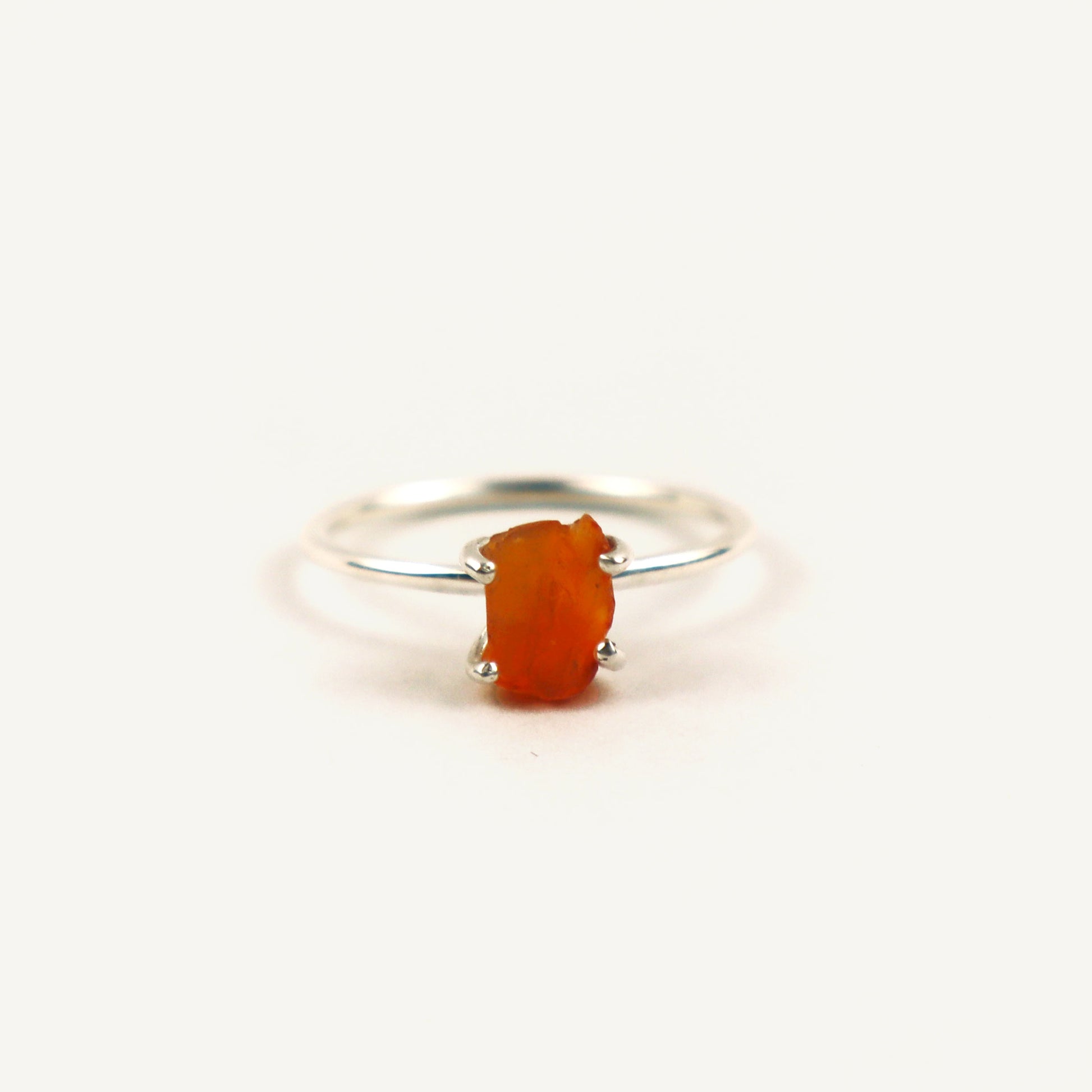 Silver ring with a red stone on a white background