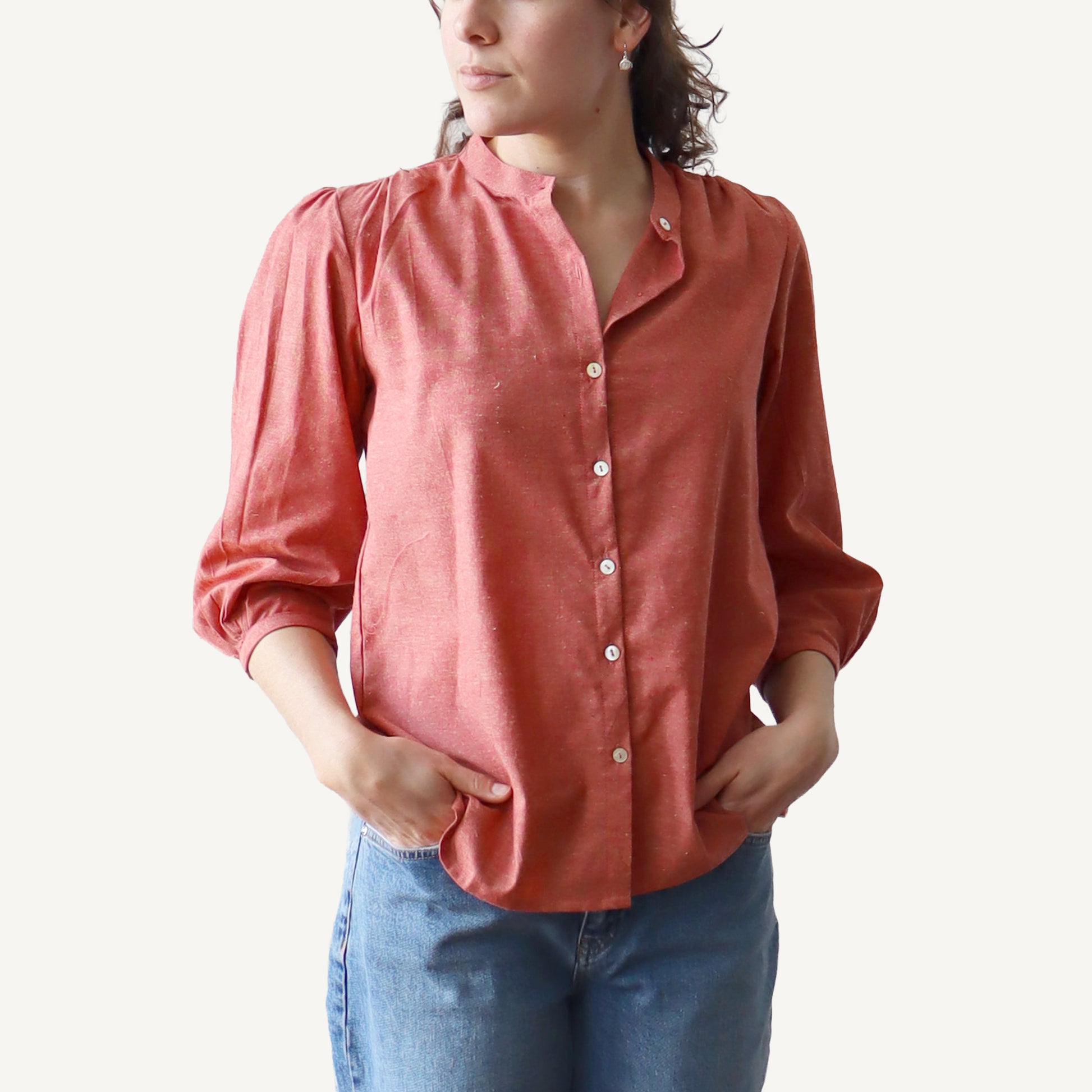 Person wearing a red shirt and blue jeans on a white background