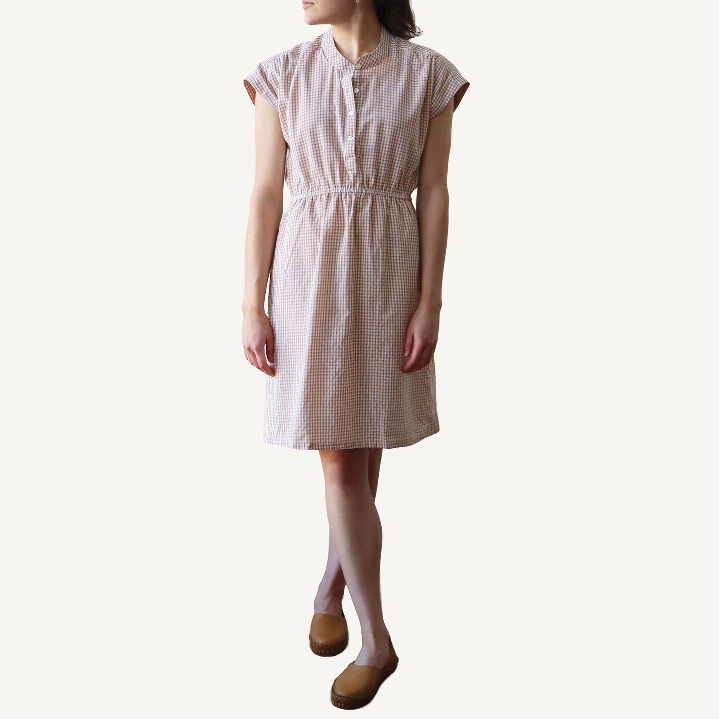 Woman wearing a checkered dress on a white background