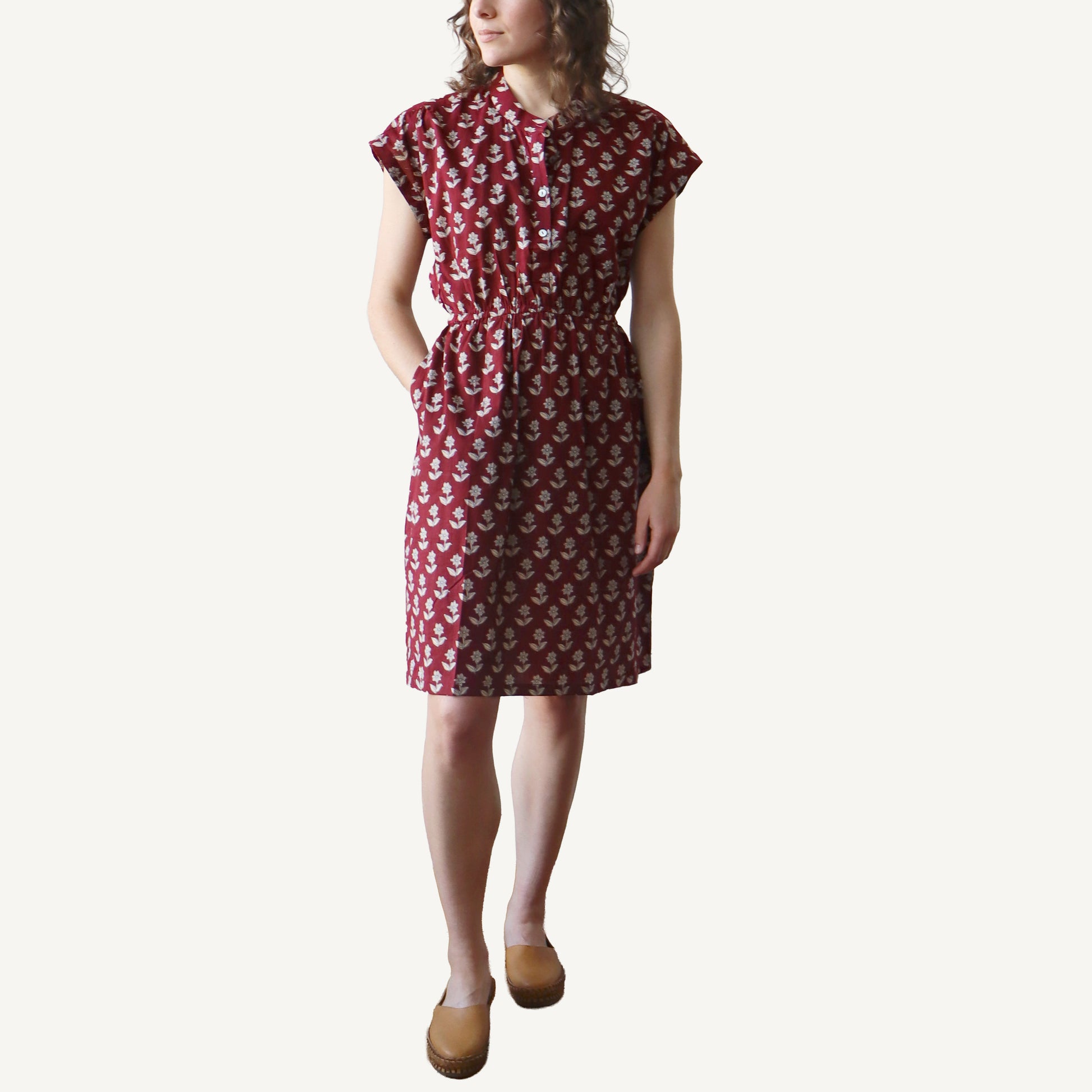 Woman wearing a red patterned dress on a white background