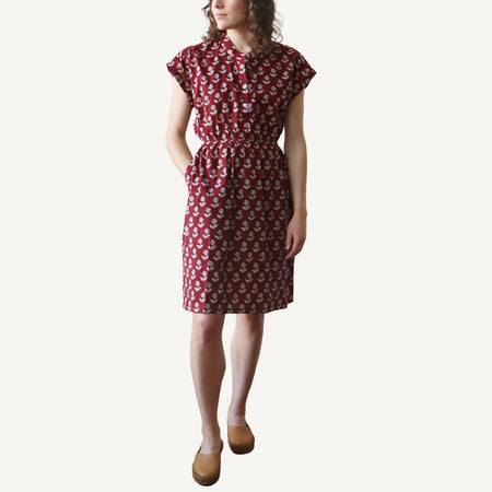 Woman wearing a red patterned dress on a white background