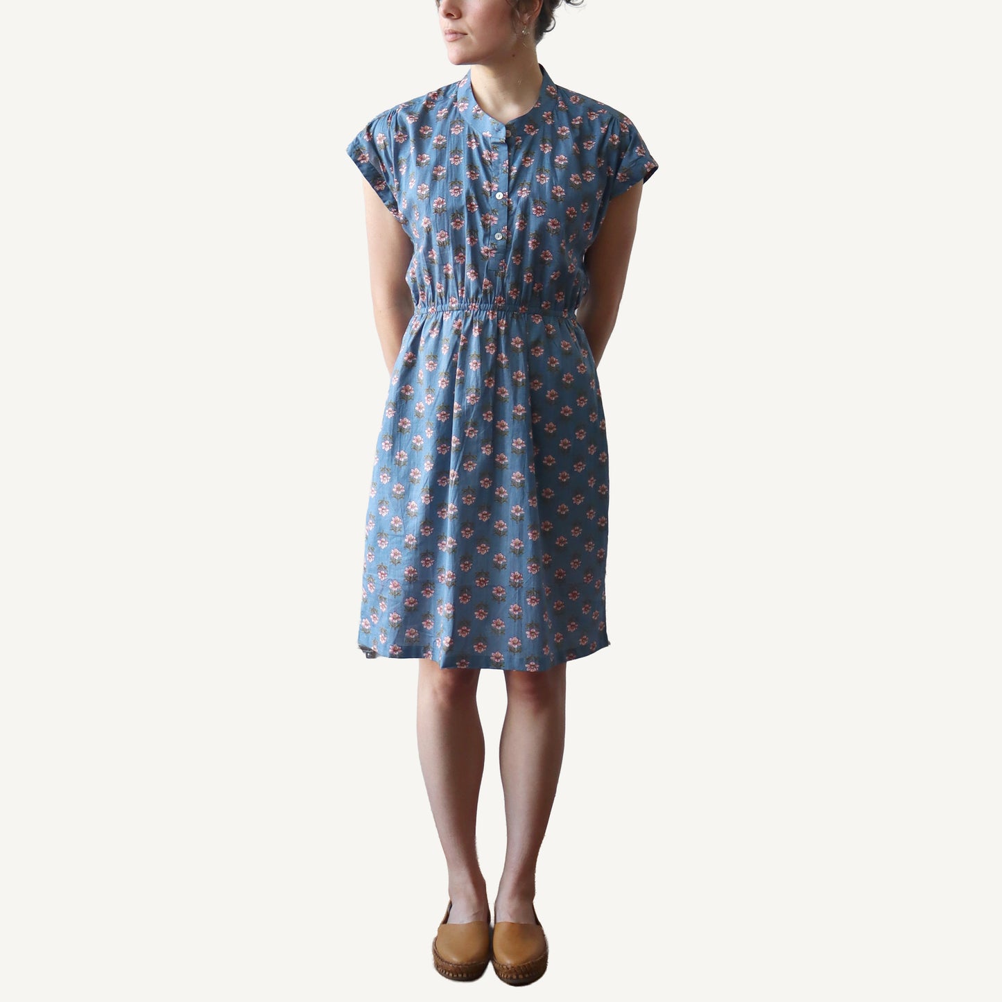 Woman wearing a blue floral dress on a white background