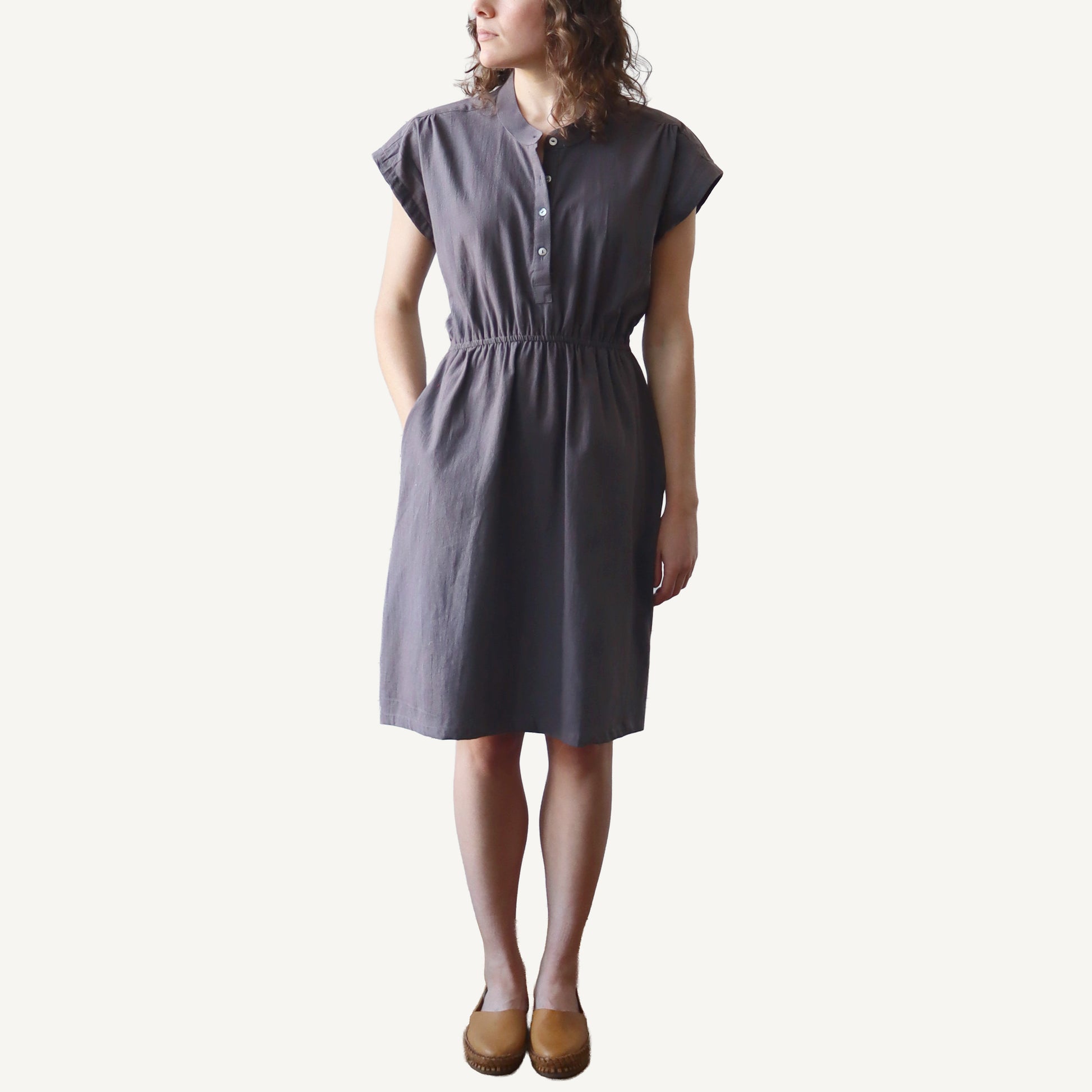 Woman wearing a gray dress on a white background